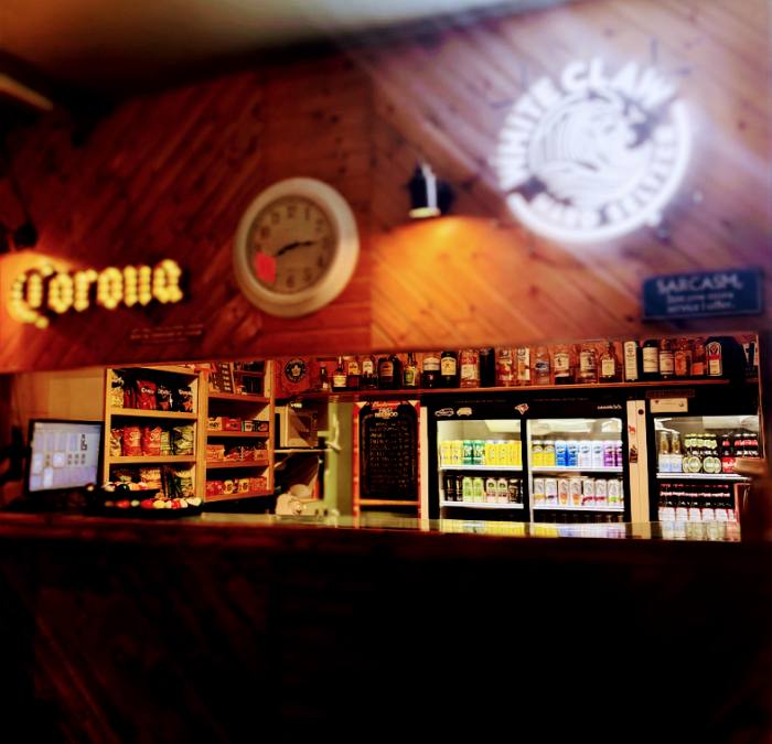 End Pocket's bar counter with drink coolers and liquor shelf